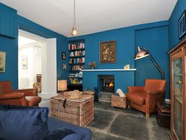 A living room with a fireplace and bookshelves at 84 Fore Street in Port Isaac