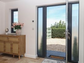 An entrance with a console table and flowers at Harescombe Lodge Morchard Bishop