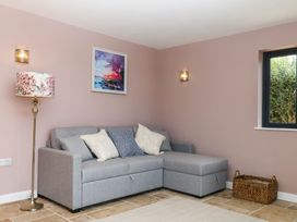 A living room with a grey sofa and a painting at Harescombe Lodge Morchard Bishop