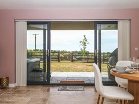 A dining room with sliding doors leading to a garden at Harescombe Lodge Morchard Bishop