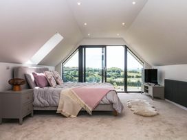 A bedroom with a bed and television at Harescombe Lodge in Morchard Bishop