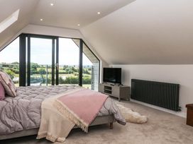 A bedroom with a bed and television at Harescombe Lodge in Morchard Bishop