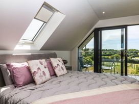 A bedroom with a bed near a balcony at Harescombe Lodge in Morchard Bishop