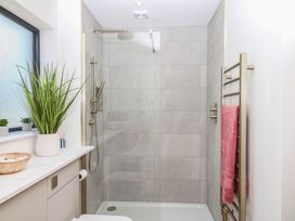 A bathroom with a shower and towel rack at Harescombe Lodge in Morchard Bishop