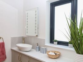 A bathroom with a sink, mirror, and towel at Harescombe Lodge in Morchard Bishop