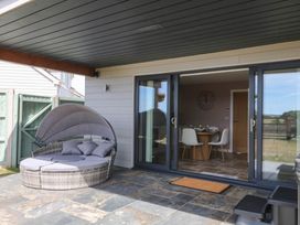 An outdoor area with a patio and sliding glass doors at Harescombe Lodge in Morchard Bishop