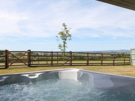 An outdoor area with a hot tub and a view of the landscape at Harescombe Lodge in Morchard Bishop