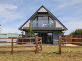 A house with a balcony and fence at Harescombe Lodge in Morchard Bishop