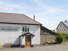 Exterior view of The London Inn with benches at The London Inn in Morchard Bishop
