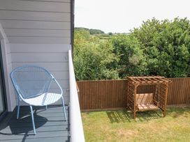 A balcony with a chair and swing at Harescombe Lodge in Morchard Bishop