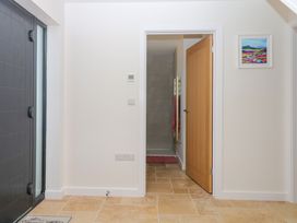 A hallway with a door and a bathroom access at Harescombe Lodge in Morchard Bishop