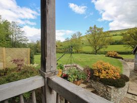 A garden with trees and a hanging basket at Pultheley Cottage Hyssington near Churchstoke