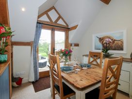 A dining room with a wooden table and chairs at Pultheley Cottage in Hyssington near Churchstoke