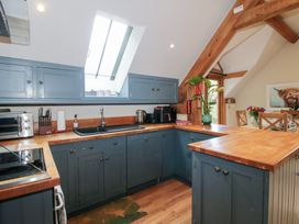 A kitchen with blue cabinets and wooden counters at Pultheley Cottage Hyssington near Churchstoke