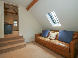 A seating area with a sofa and staircase at Pultheley Cottage in Hyssington near Churchstoke