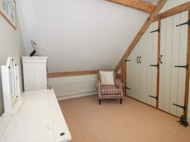 A bedroom with an armchair and vanity at Pultheley Cottage Hyssington near Churchstoke