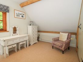 A bedroom with a dresser and chair at Pultheley Cottage in Hyssington near Churchstoke