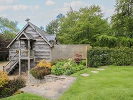 A wooden building with a staircase and garden at Pultheley Cottage Hyssington near Churchstoke