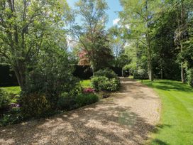 A garden with a gravel pathway and various trees and plants at Pultheley Cottage in Hyssington near Churchstoke