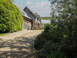 A gravel path leading past wooden buildings at Pultheley Cottage Hyssington near Churchstoke