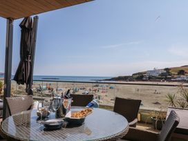 An outdoor dining area with a table and view of the beach at 4 Burgh Island Causeway in Bigbury