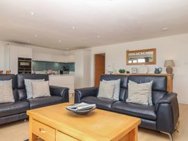 A living room with sofas and kitchen area at 4 Burgh Island Causeway in Bigbury