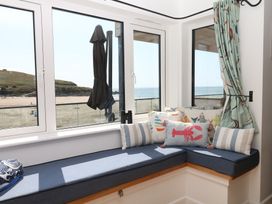 A sunroom with a sea view and cushions at 4 Burgh Island Causeway Bigbury