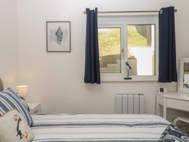 A bedroom with a bed and window at 4 Burgh Island Causeway in Bigbury