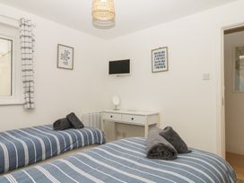 A bedroom with two beds and a desk at 4 Burgh Island Causeway in Bigbury