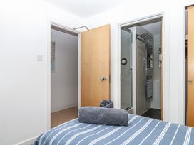 A bedroom with a bed and a bathroom doorway at 4 Burgh Island Causeway in Bigbury