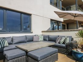 An outdoor seating area with a sectional couch and table at 4 Burgh Island Causeway Bigbury