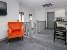 An open area with a chair and staircase at Fell View Cottage Lambrigg near Kendal