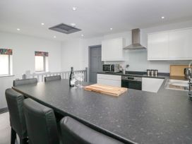 A kitchen with a table and stools at Fell View Cottage in Lambrigg near Kendal