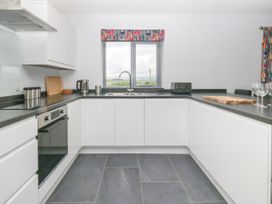 A kitchen with appliances and a window at Fell View Cottage in Lambrigg near Kendal
