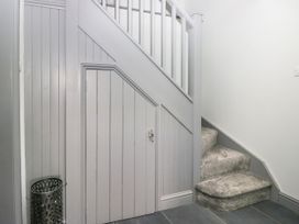 A hallway with stairs and a door at Fell View Cottage in Lambrigg near Kendal