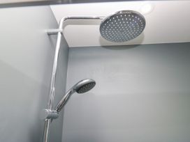 A shower head and arm in a bathroom at Fell View Cottage Lambrigg near Kendal