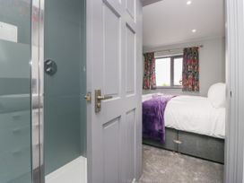 A bedroom with a bed and curtains at Fell View Cottage in Lambrigg near Kendal