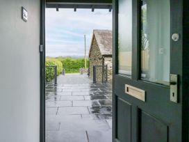An entrance view with a door open to a path and building at Fell View Cottage Lambrigg near Kendal