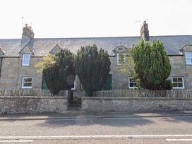 A house with trees and a fence at Bruno's Bothy Middleton near Belford