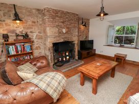 A living room with a fireplace and a sofa at Bruno's Bothy in Middleton near Belford