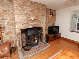 A living room with a fireplace and television at Bruno's Bothy Middleton near Belford