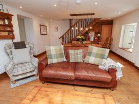 A living room with a sofa and armchair at Bruno's Bothy Middleton near Belford