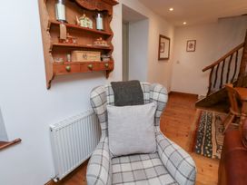 A living room with a shelf and a chair at Bruno's Bothy Middleton near Belford