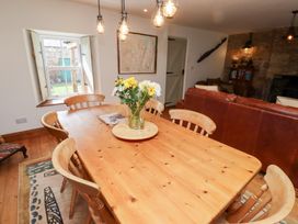 A dining room with a wooden table and chairs at Bruno's Bothy Middleton near Belford