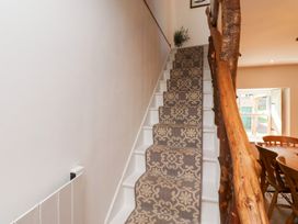 A staircase with carpet and wooden handrail at Bruno's Bothy in Middleton near Belford