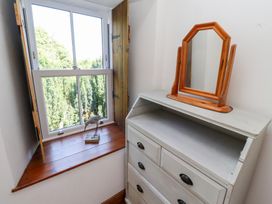 A bedroom with a window and a mirror at Bruno's Bothy Middleton near Belford