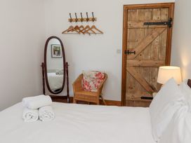 A bedroom with a bed and a mirror at Bruno's Bothy Middleton near Belford