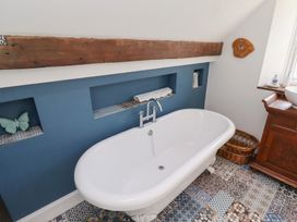 A bathroom with a bathtub and sink at Bruno's Bothy Middleton near Belford