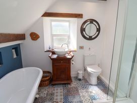 A bathroom with a bathtub, sink and toilet at Bruno's Bothy Middleton near Belford