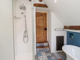 A bathroom with a shower and bathtub at Bruno's Bothy Middleton near Belford